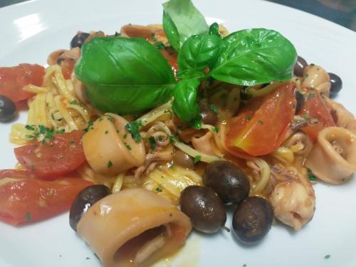 a white plate of food with pasta and vegetables at Hotel Morandi in Sanremo