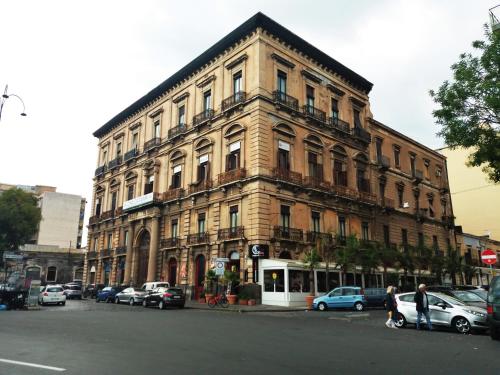 a large brick building with cars parked in front of it at B&B Oriental Palace in Catania