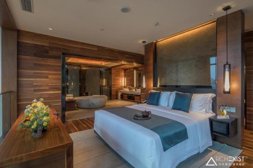 a bedroom with a large bed and a bath tub at Jinshuo Holiday Hotel in Mianyang