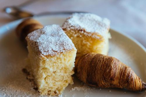 a white plate with a piece of cake and a pastry at Hotel Cresol in Calaceite