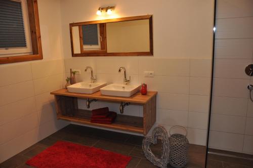 bagno con 2 lavandini e specchio di Ferienwohnung Christian a Aschau