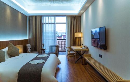 a hotel room with a bed and a desk and a television at Lin Yin Art Hotel Shanghai（Pudong airport） in Shanghai