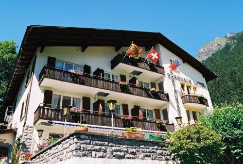 a building with balconies and flags on it at Hotel Berghaus in Wengen
