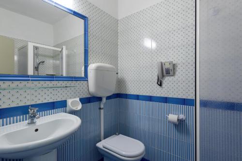 a bathroom with a sink, toilet and mirror at Centro Vacanze La Limonaia in Limone sul Garda