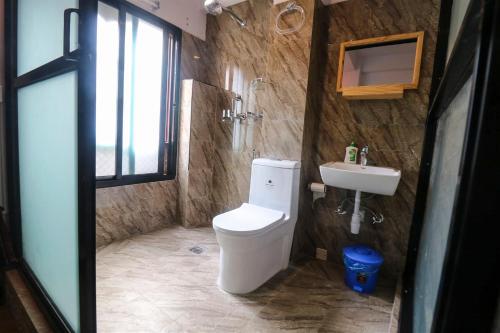 a bathroom with a toilet and a sink at Easy Homes - Ashok Stupa in Pātan