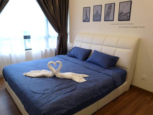 a bedroom with a bed with a swan towel on it at Luxury Resort Suite Kuala Lumpur@5mins to Mid Valley, Sunway in Kuala Lumpur
