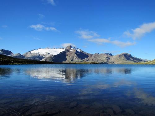a mountain reflection in a lake with snow at Residence Aichner in Brunico