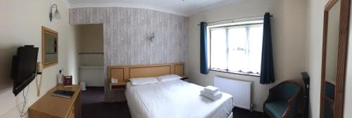 a hotel room with a bed and a window at The Abbey Hotel and conference centre in Minster