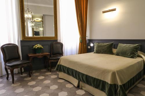 una camera da letto con un letto, due sedie e uno specchio di Residenza Ki a Roma