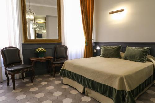 ローマにあるレジデンサ キーのベッドルーム1室(ベッド1台、椅子2脚、鏡付)
