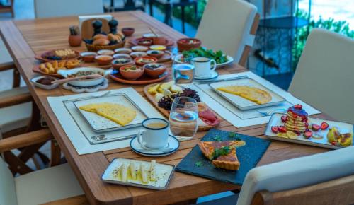 a wooden table with plates of food on it at Seraphim Cave Suites & SPA in Urgup
