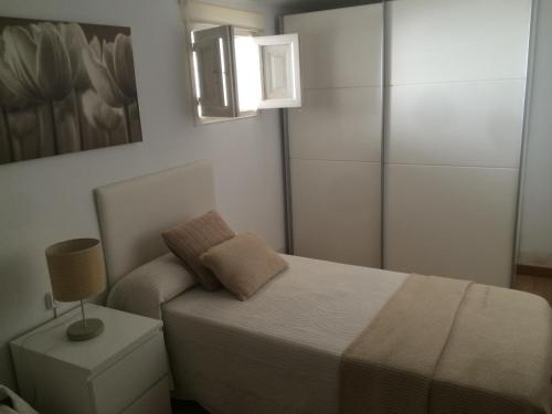 グラナダにある6 Calle Profesor Albaredaの小さなベッドルーム(ベッド1台、ランプ付)
