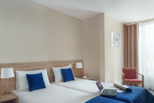 a hotel room with a bed with a laptop on it at Hotel Molo in Sopot