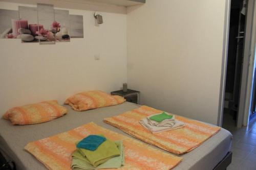 2 Betten in einem Zimmer mit Handtüchern darauf in der Unterkunft Les Residences Pinea in Calvi