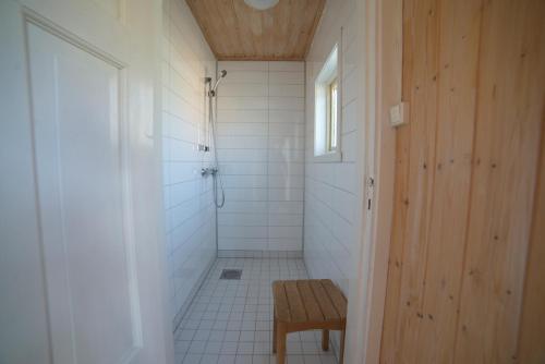 a bathroom with a shower with a bench in it at Gullesfjord Camping in Gullesfjord