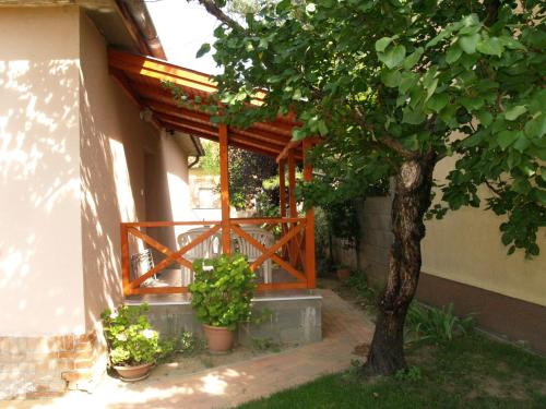 a wooden entrance to a house with a tree at Liliom Apartman in Gyula
