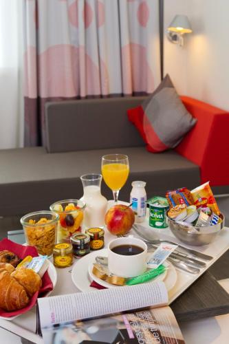a table with breakfast foods and a glass of orange juice at Novotel Leuven Centrum in Leuven