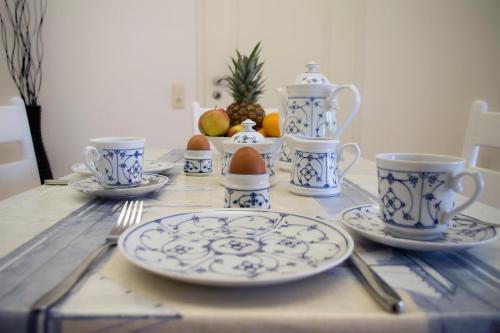 une table avec des tasses et des assiettes bleues et blanches dans l'établissement Haus "Zur Düne", à Norddorf auf Amrum