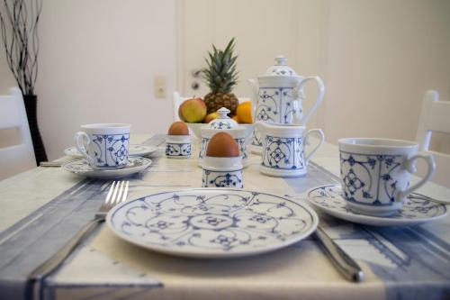 a table with blue and white cups and plates on it at Haus "Zur Düne" in Norddorf