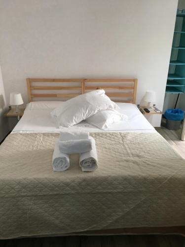 a bed with two towels and two pillows on it at Annette Rooms in Bari