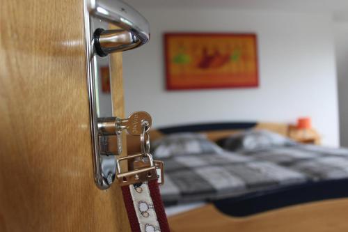 a door with a latch in a bedroom with a bed at Ferienwohnung & Gästezimmer Schrichten in Schmallenberg