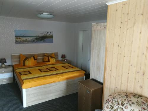 a bedroom with a bed with a yellow bedspread at Zingster Ostseeklause in Zingst