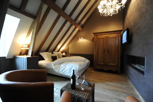 a bedroom with a bed and a chandelier at B&B De Rentmeesterhoeve in Reningelst