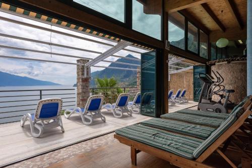 a room with chairs and a bench on a deck at Centro Vacanze La Limonaia in Limone sul Garda