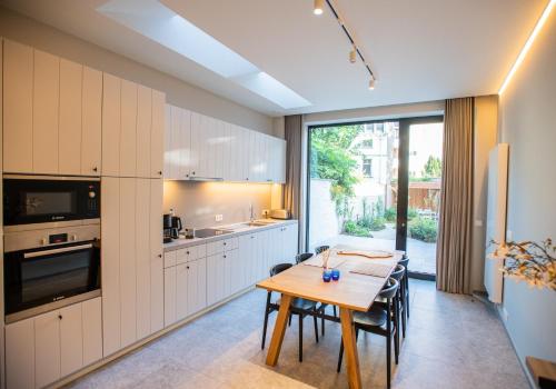 Una cocina con una mesa de madera y un comedor. en Blossom & Bloom, en Brujas