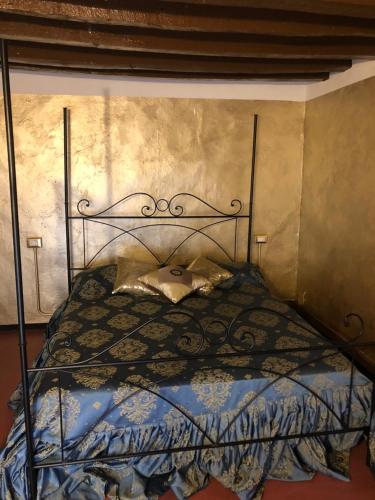 a bedroom with a bed with a wrought iron headboard at Dimora del Podestà in CastellʼArquato