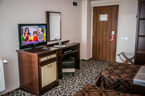 a hotel room with a television on a dresser at Hotel Megalos in Constanţa