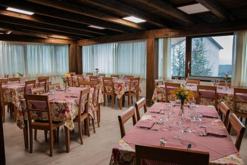 uma sala de jantar com mesas, cadeiras e janelas em La Villa Resort Pignola em Pignola