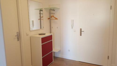 App-Syltliebe-Haus-Ankerlicht-Whg-70 في فيسترلاند: خزانة مع خزانة ملابس حمراء ومرآة