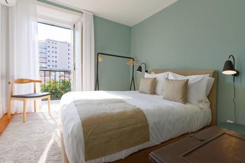 a bedroom with a large bed and a large window at Boutique Chiado Duplex in Lisbon