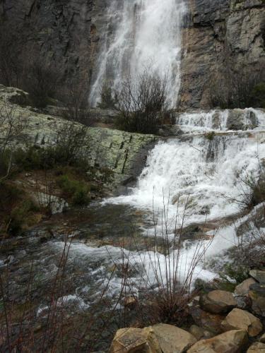 a waterfall on the side of a mountain with snow at Casa Rural Los Robles in Valverde de los Arroyos
