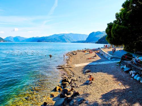 a beach with people swimming in the water at 7 Lake Sweet Home in San Siro