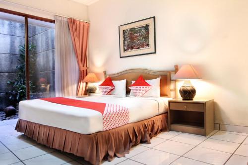 um quarto com uma cama grande e almofadas vermelhas em OYO 123 Puri Lotus em Jakarta