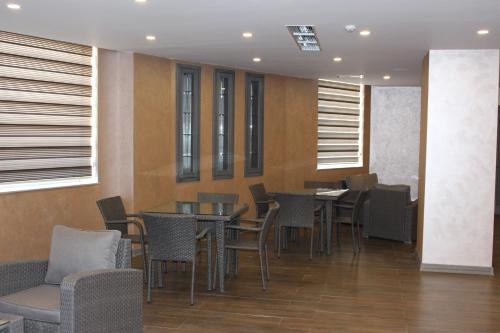 a dining room with tables and chairs and windows at Sky Hotel Baku in Baku