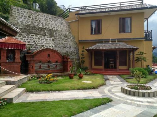 a house with a stone wall and a courtyard at The Lapsi Tree in Nagarkot