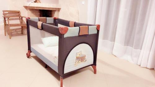 a childs bed with a crib with a fireplace at Sozia in Perdhika