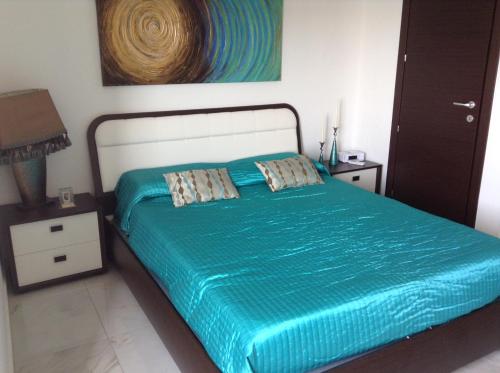 a bedroom with a bed with a blue comforter at Seafront Apartment With Pool in St Paul's Bay