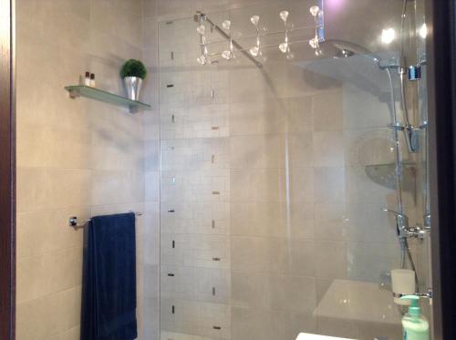 een badkamer met een douche en een blauwe handdoek bij Seafront Apartment With Pool in St Paul's Bay