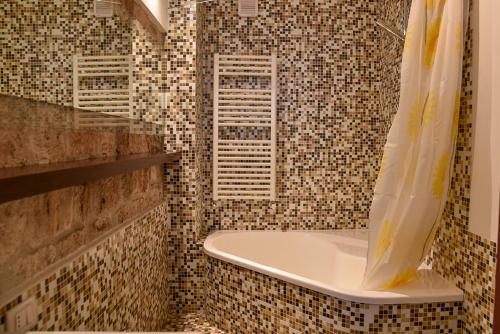 baño con bañera y pared de azulejos en Patty's house, en Ascoli Piceno