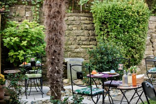 a patio with tables and chairs in a garden at Miracolo di Mare Retro in Piran
