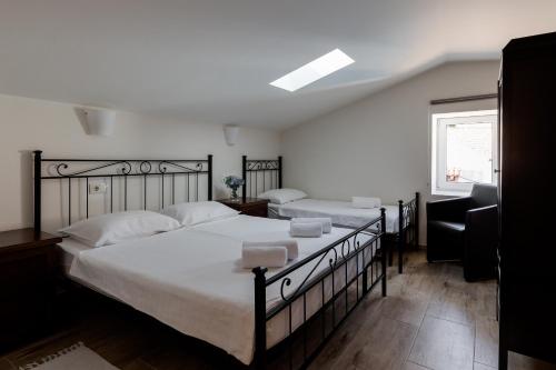 a bedroom with two beds with white sheets and a window at Miracolo di Mare Retro in Piran
