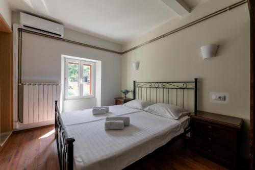 a bedroom with a bed with white sheets and a window at B&B Miracolo di Mare Retro in Piran