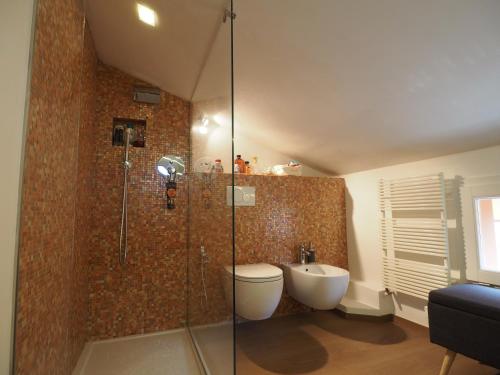 une salle de bains avec toilettes et douche en verre dans l'établissement Tetti Rossi, à Bologne