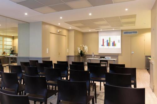 a conference room with black chairs and a screen at Paris Bastille in Paris
