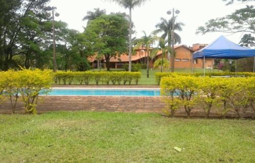 a swimming pool with a blue tent in a yard at Chacara Jequitiba in Itu