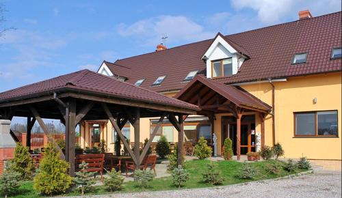 una casa con un cenador frente a ella en Kazimierzówka, en Elbląg